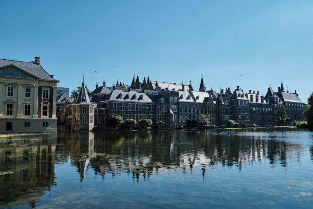 Scenic view of historic buildings reflecting on a serene canal in a European city.