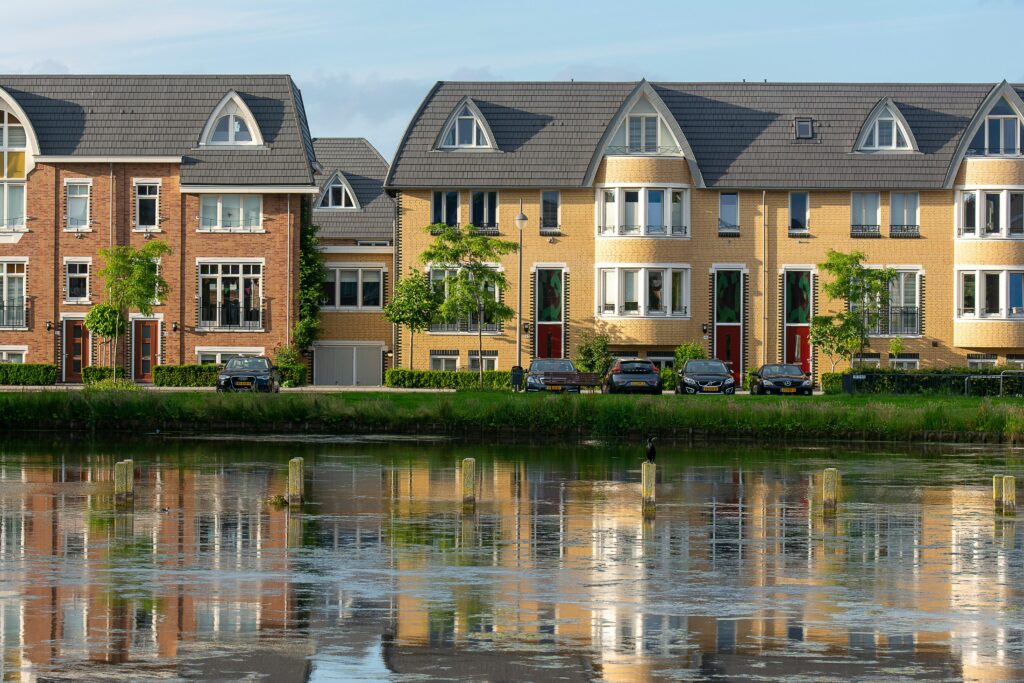 Symmetrical view of stylish residential buildings along a tranquil river in Voorschoten, Netherlands.