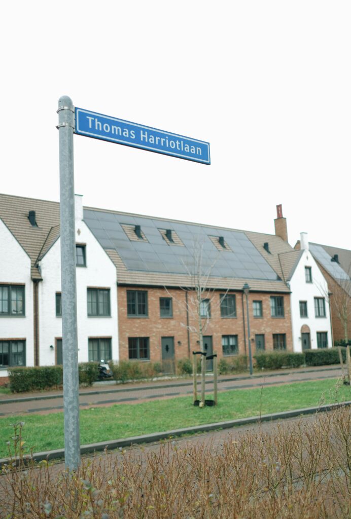 Quaint residential street view in Hoofddorp, Netherlands, featuring a Thomas Harriotlaan sign.