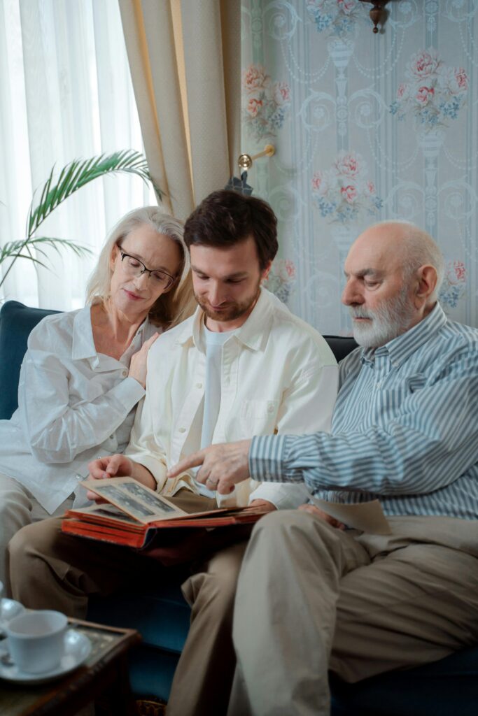 Three generations of a family share memories by looking through an old photo album.